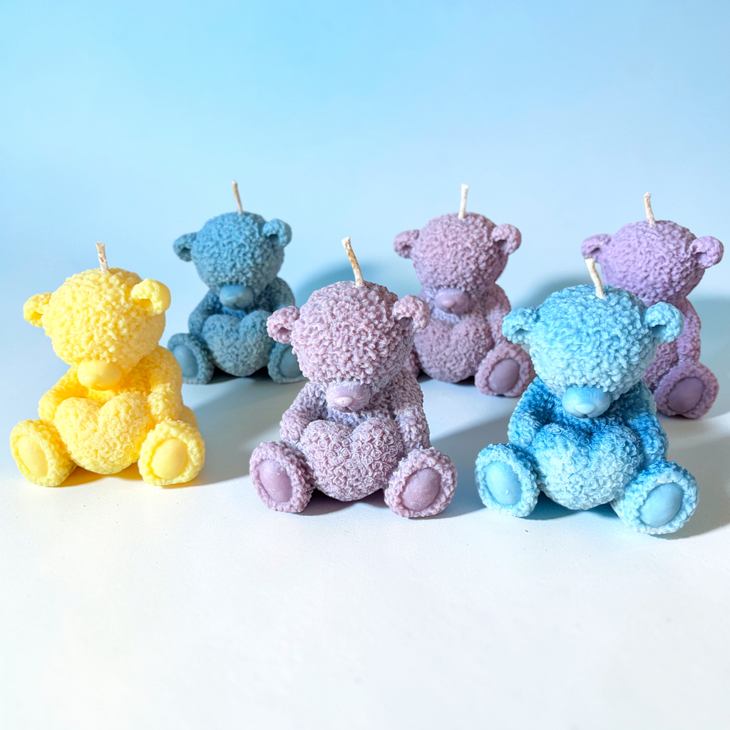 Teddy bear holding a heart decorative candle