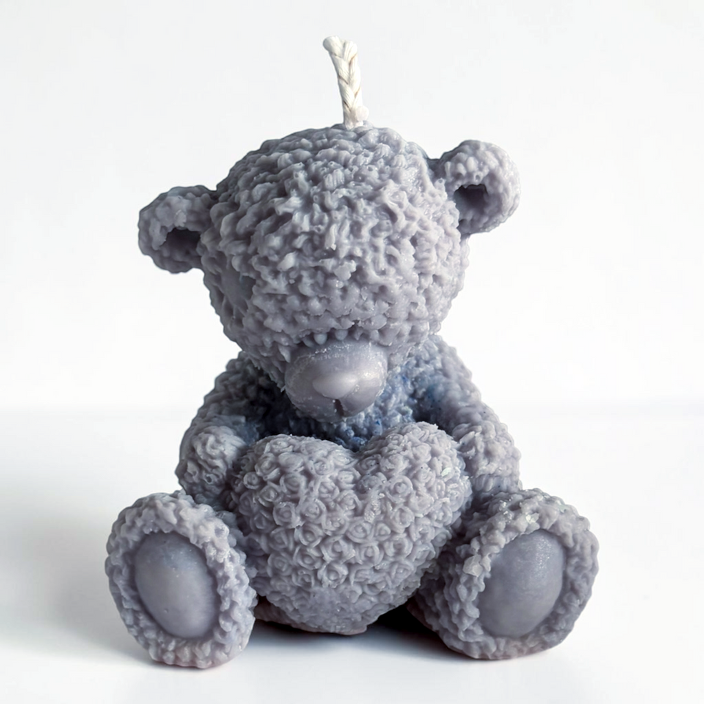 Teddy bear holding a heart decorative candle
